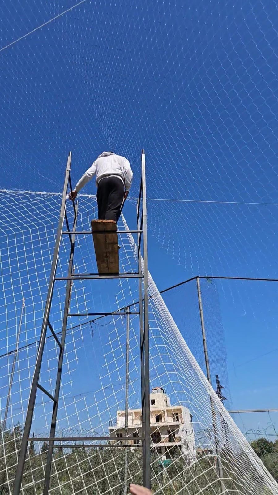 TurfFix Pro fitting high perimeter netting on a sports court in Lebanon