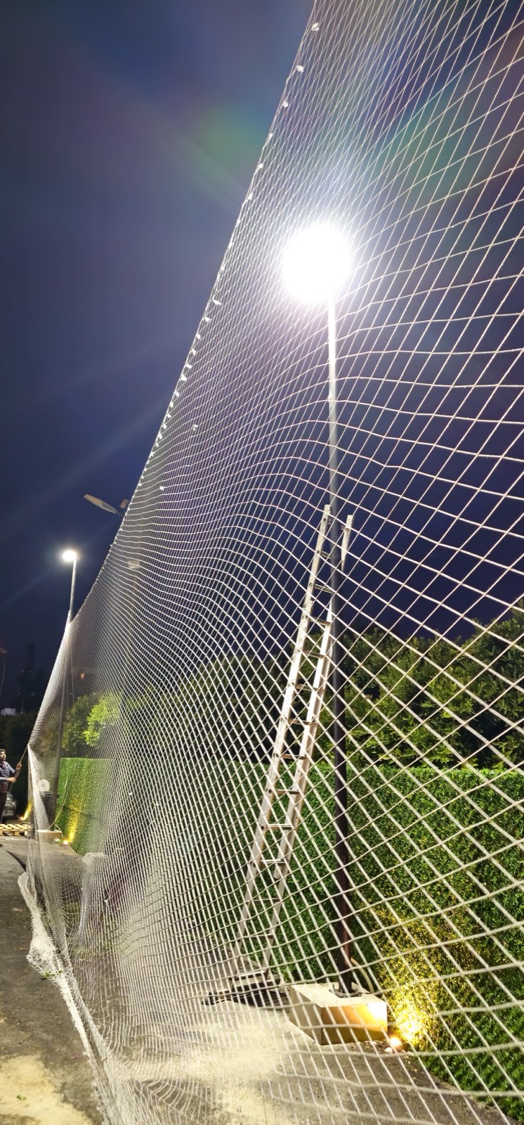 TurfFix Pro installing perimeter netting under floodlights at night in Lebanon