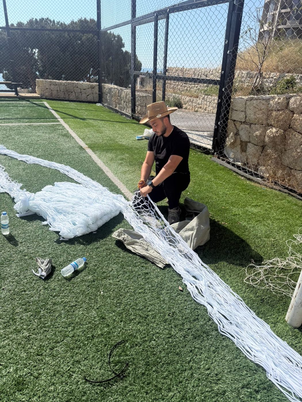 TurfFix Pro worker repairing and re-roping a sports net on a court in Lebanon