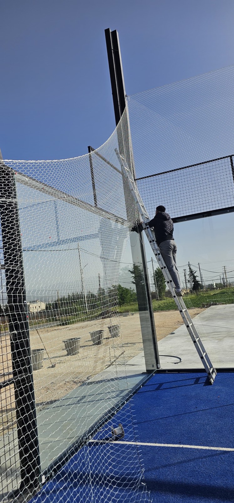 TurfFix Pro fitting netting on a blue padel court in Lebanon